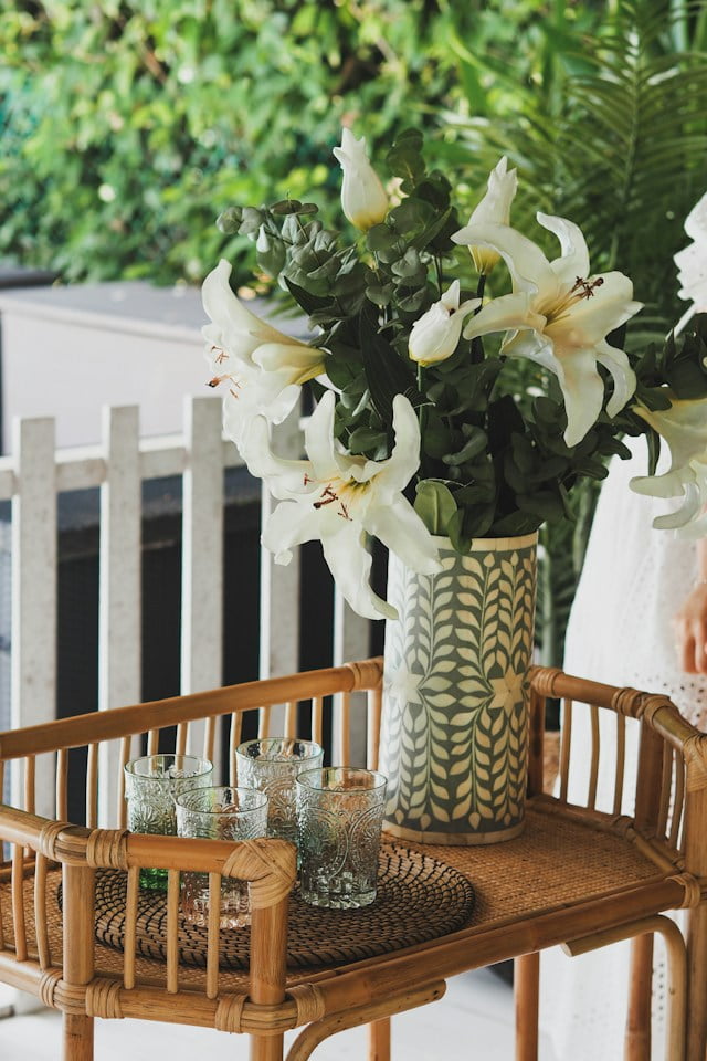 Wooden style bar cart with greenery and small potted white flowers