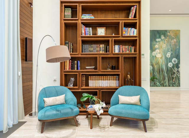 geometric style bookshelf with two blue chairs