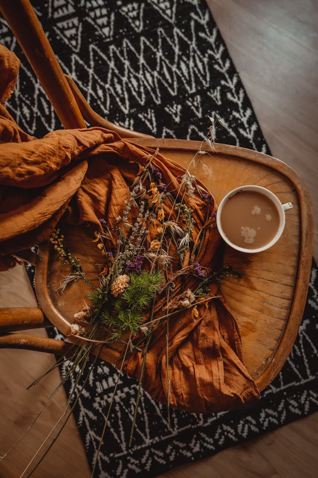 Rustic coffee bar decor ideas with mug in a wooden chair and burnt orange blanket