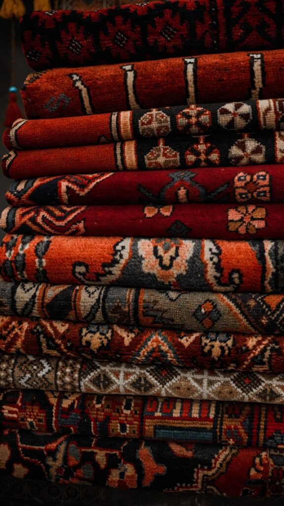 colorful collection of bright rugs stacked in a pile