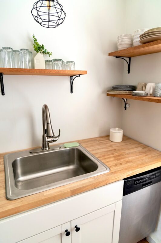 clean kitchen area with wooden floating shelves