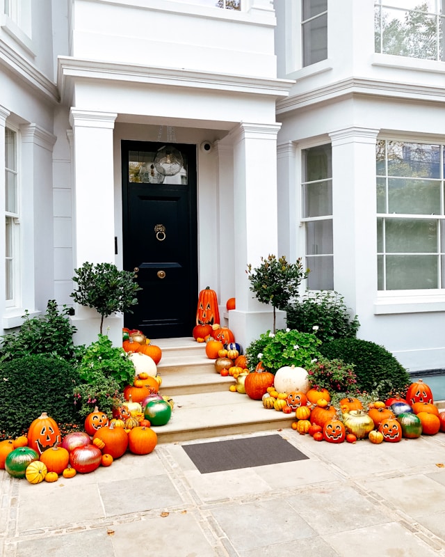 fall front porch with lots of colorful pumpkins displayed