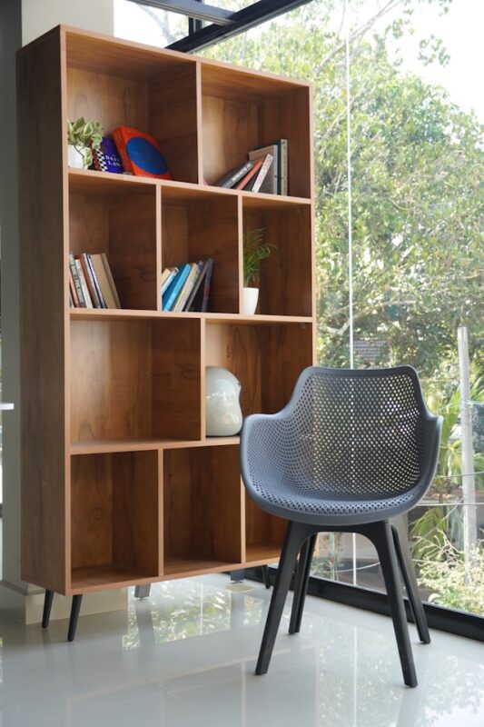 wooden cube style bookcase with gray chair