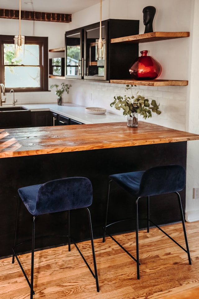 kitchen with floating shelves and blue bar stools