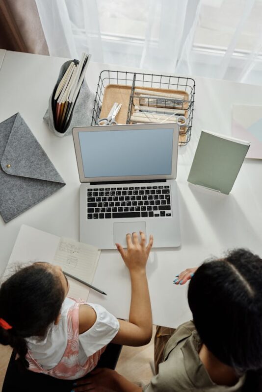 mother and daughter working together on a laptop 