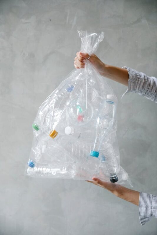 clear plastic trash bag filled with clear plastic beverage bottles