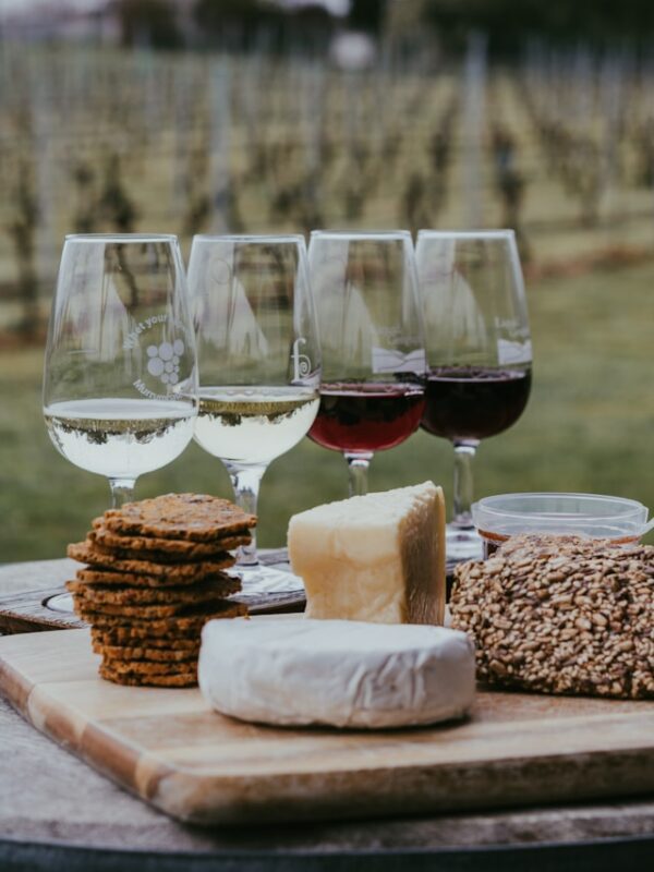 various wines in glasses next to cheese plate, labor day party ideas