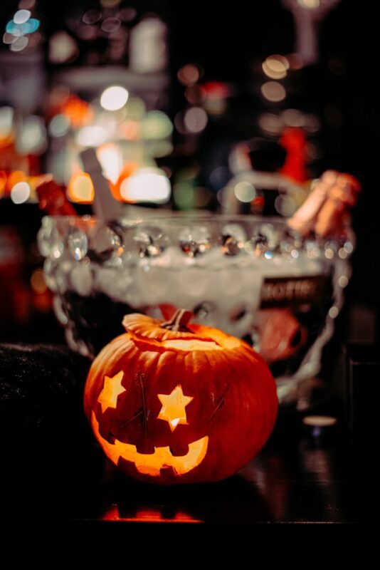 carved Halloween pumpkin in front of drink station