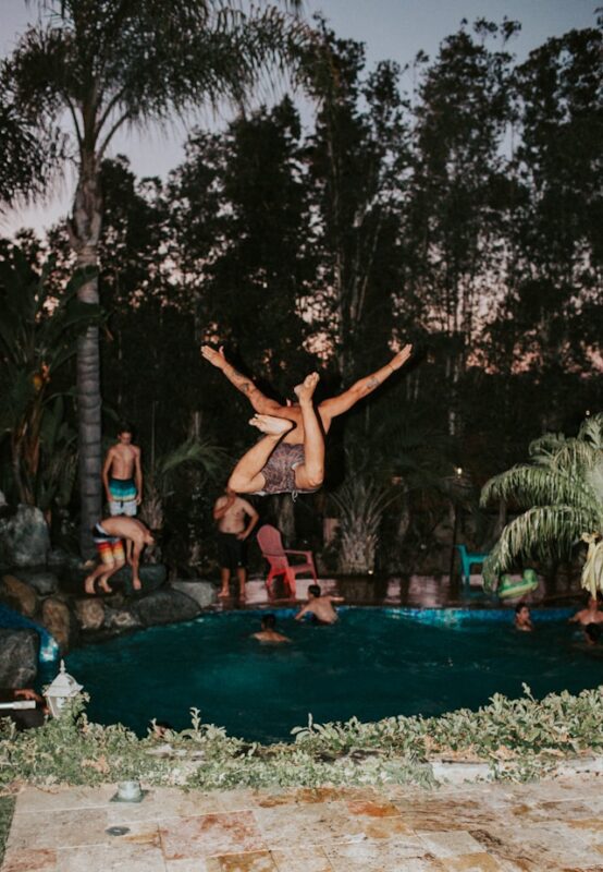 person jumping into pool at a pool party 