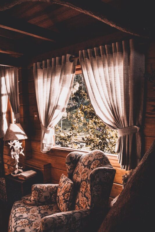 curtains pinned to the side by a patterned chair