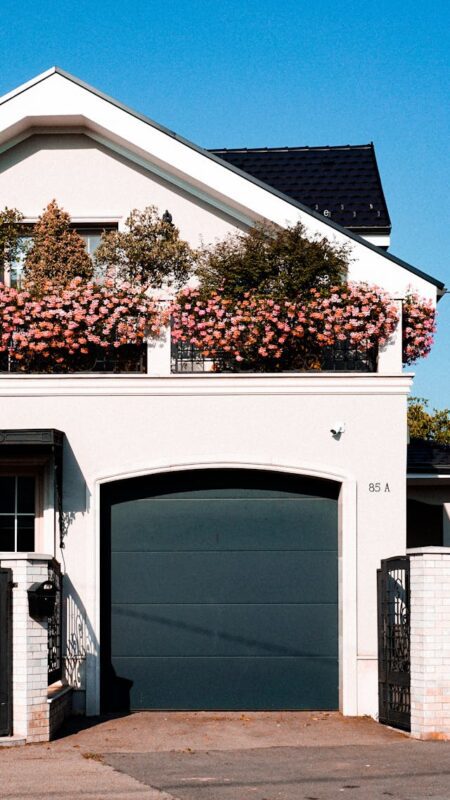 white house with pink flowers and blue garage door