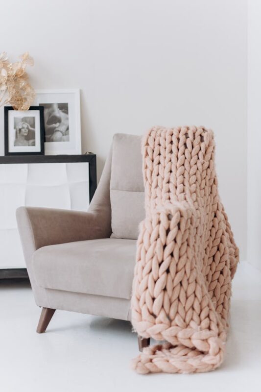 cozy reading nook chair with pink knitted blanket