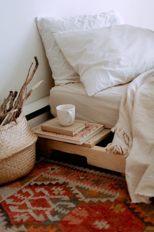 cozy reading nook with red area rug on white bed 