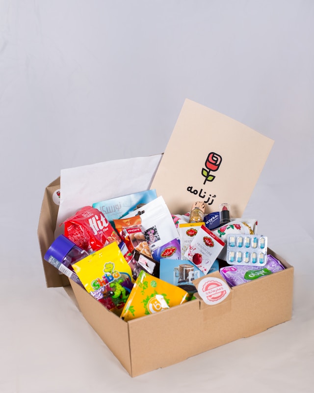 college care package in card board box filled with treats and a card