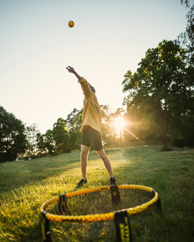 person in yellow shirt playing Spikeball