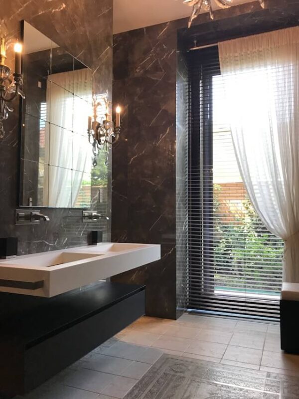 grid mirror in black marble bathroom