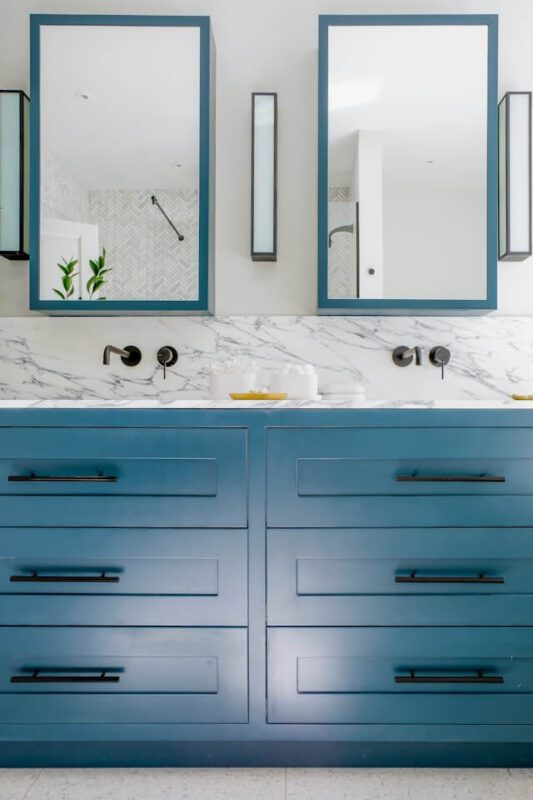 matching blue-framed rectangle bathroom mirror ideas with blue cabinets and marble counters